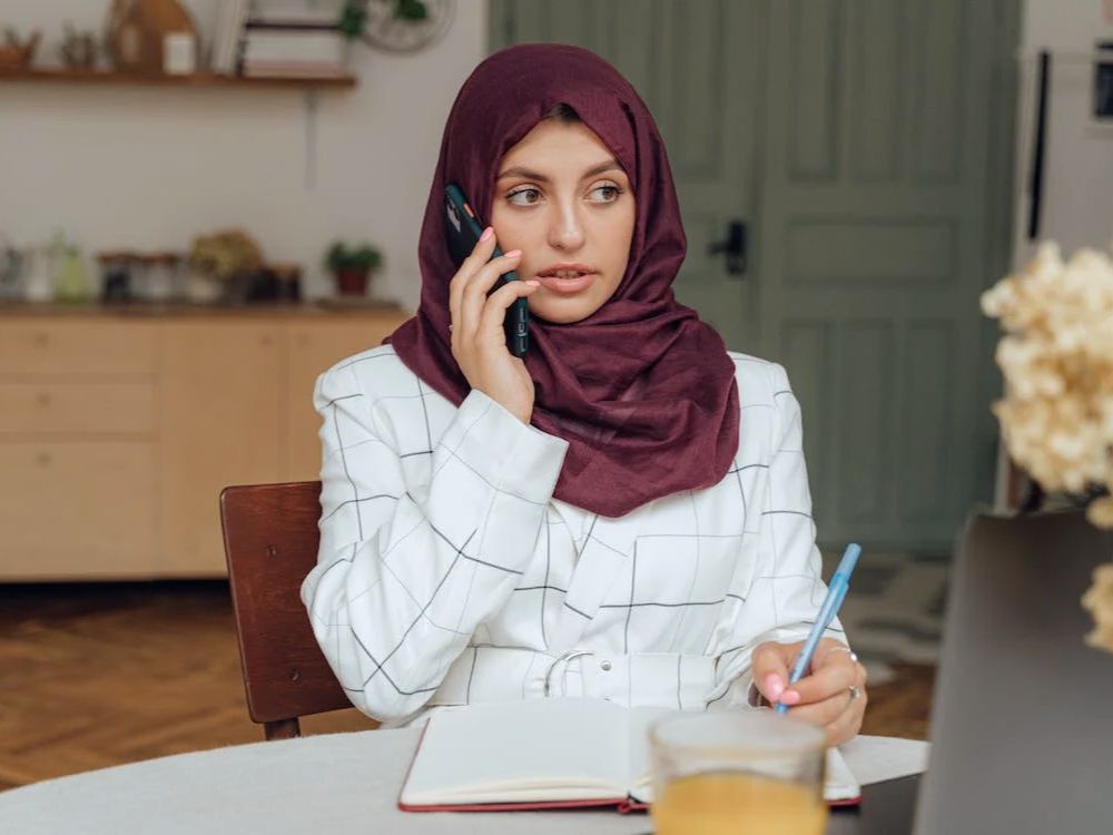 woman wearing a hijab on cell phone