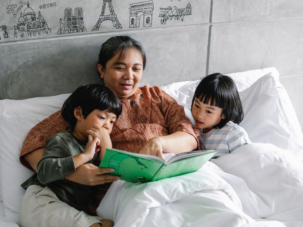 adult reading to two children