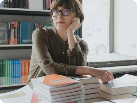 person with stacks of books 